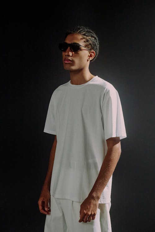 Fashion photography of man wearing sunglasses, white T-shirt and white trousers