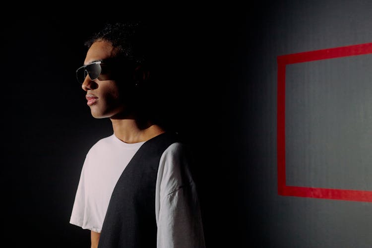 Profile View Of Man Standing In Shadow Against Black Background With Red Frame