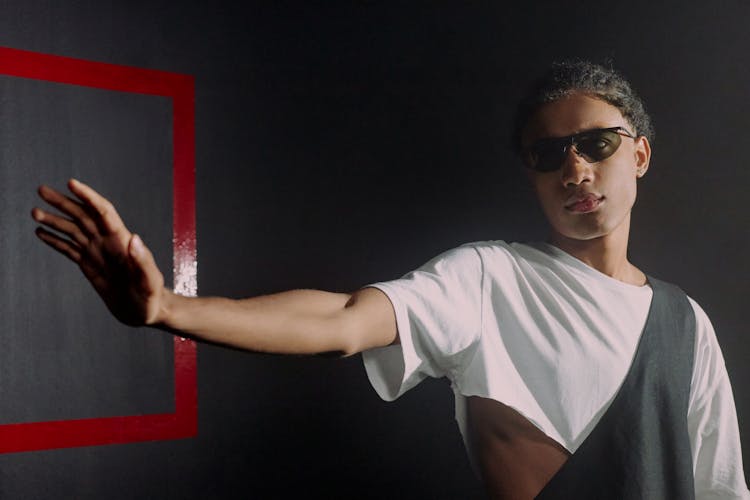 Man Raising Hand On The Black Background