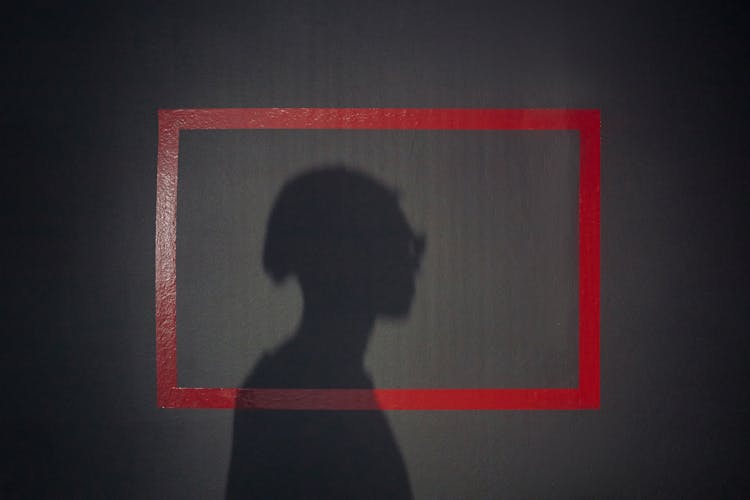 Shadow Of Mans Profile On A Black Background With Red Square