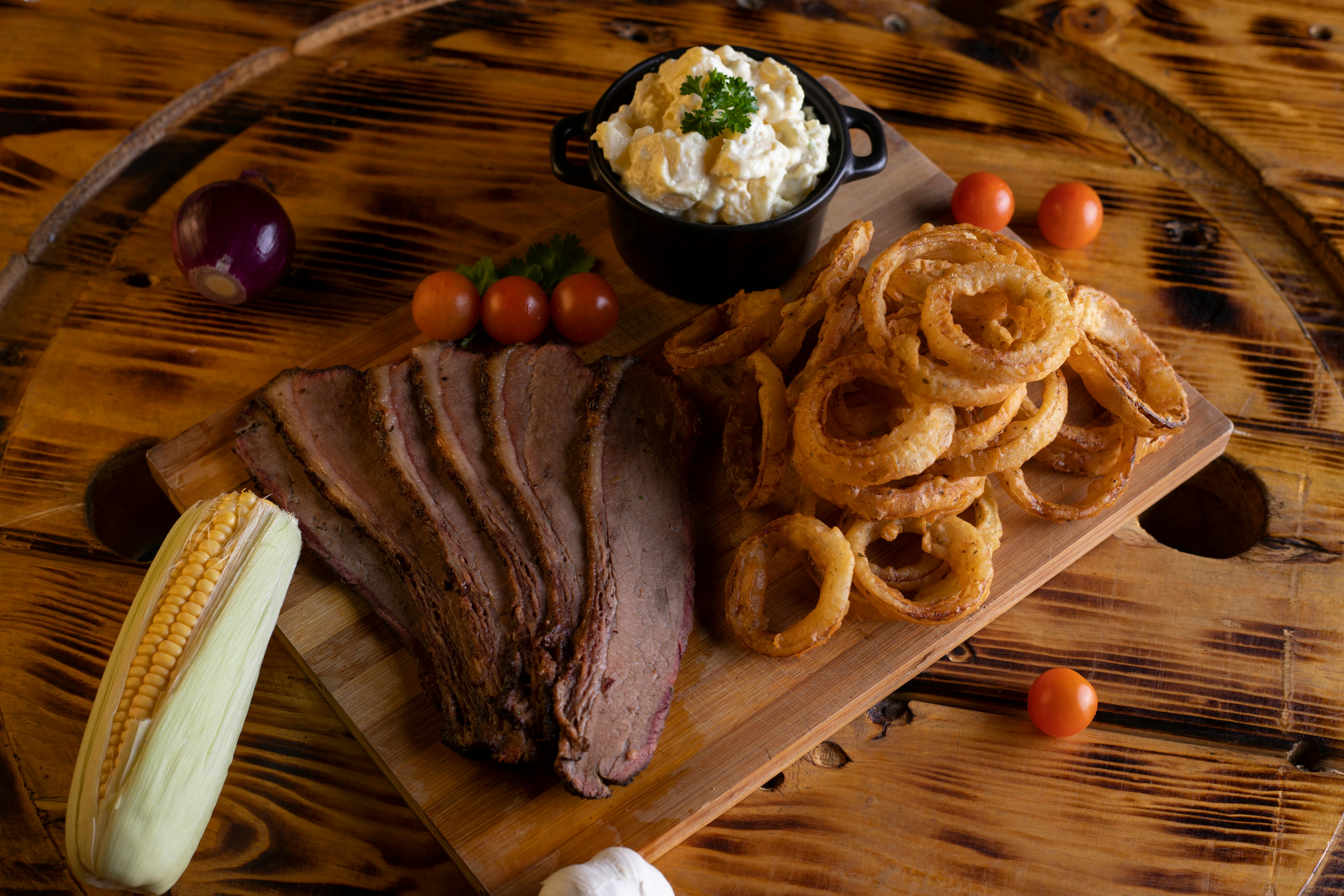 A Steak and Onion Rings on a Wooden Board · Free Stock Photo