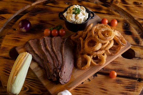 Free A Steak and Onion Rings on a Wooden Board Stock Photo