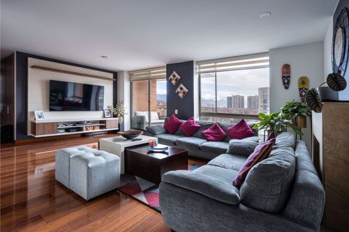Free Spacious living room with modern decor, city view, and comfortable seating. Stock Photo