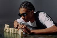 Man taking one of the domino blocks from a side view