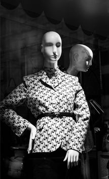 Stylish black and white mannequin display featuring patterned fashion in a storefront window.