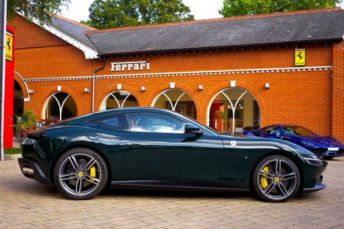 Free Luxurious green Ferrari showcased at a UK dealership, highlighting sleek design and sportiness. Stock Photo