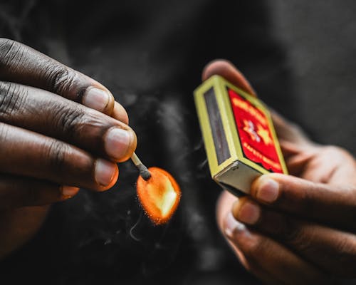 Free A Person Holding Burning Match Stick Stock Photo