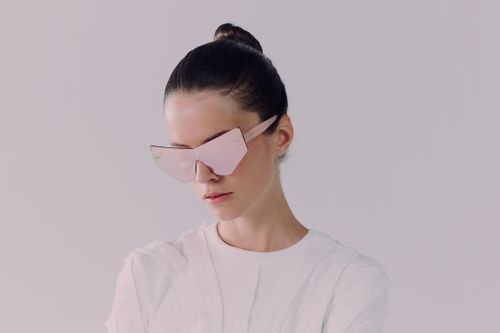 Free Portrait of a woman with sleek hair and unique pink sunglasses, showcasing fashion-forward style in a studio setting. Stock Photo