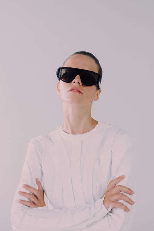 Free Stylish woman with short hair in futuristic sunglasses posing in a minimalist studio. Stock Photo