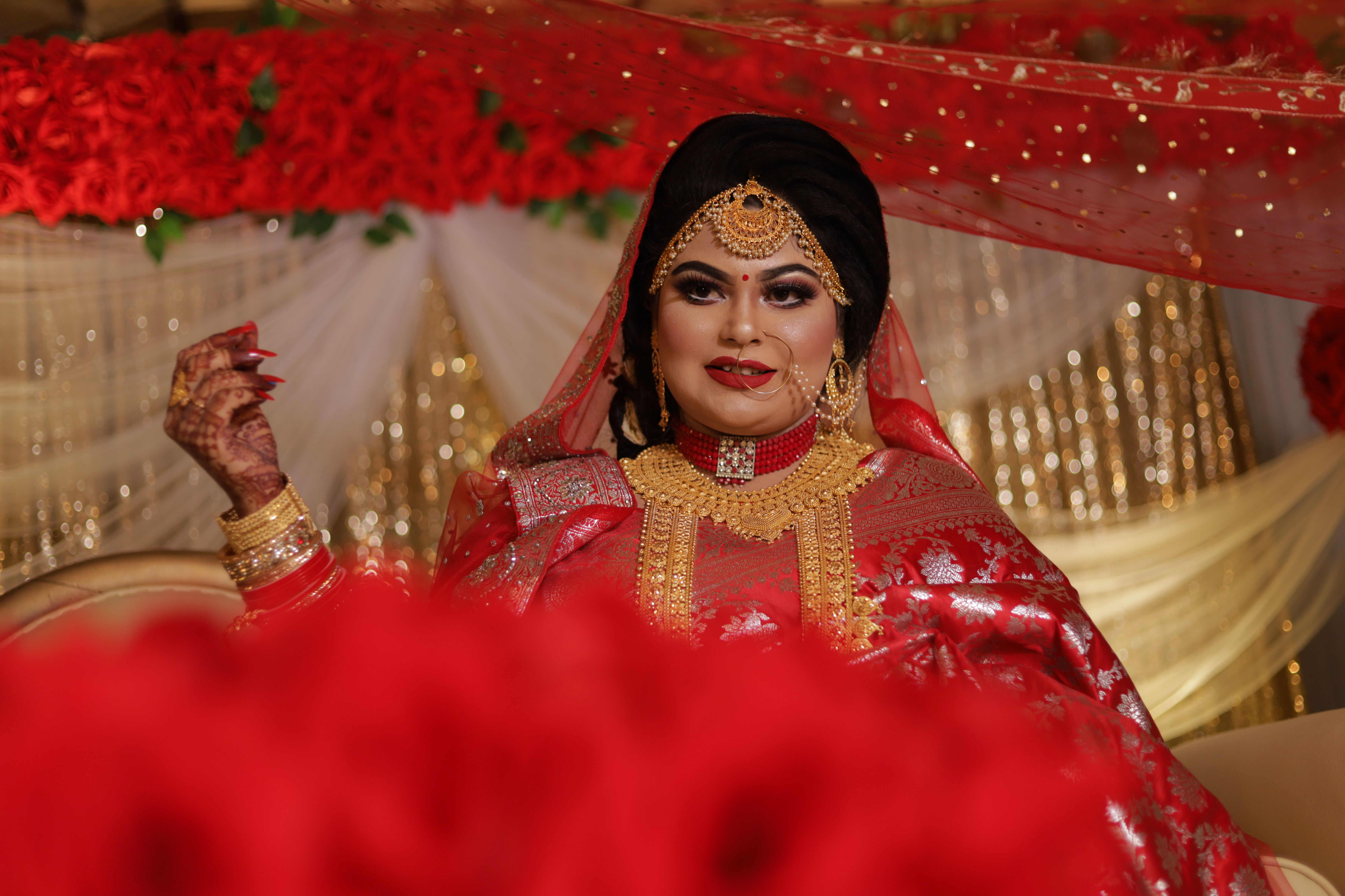 A Pretty Woman in Red and Gold Saree Posing · Free Stock Photo