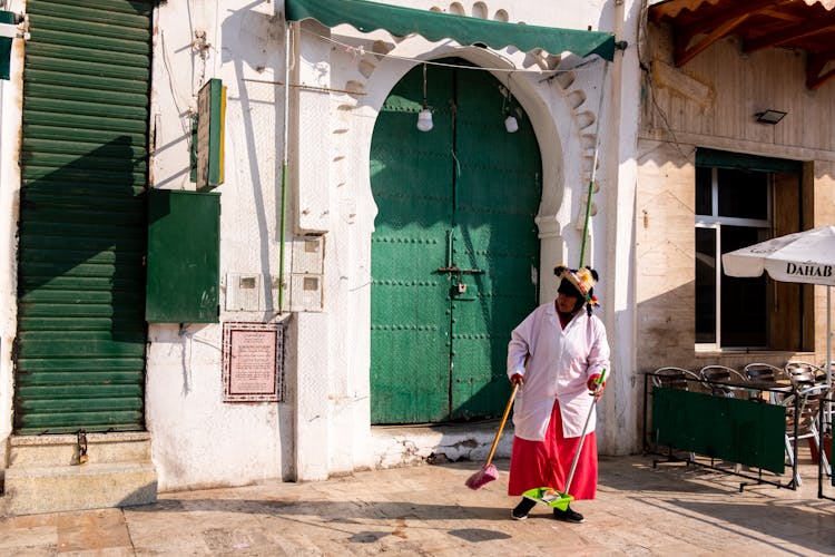 Person In White Long Sleeves Polo Holding A Broom