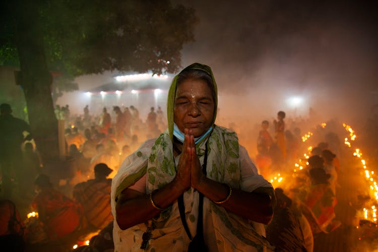 An Elderly Woman Praying At Night 