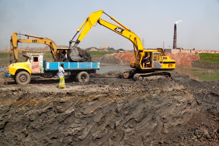 Yellow Backhoe Putting Soil On The Truck