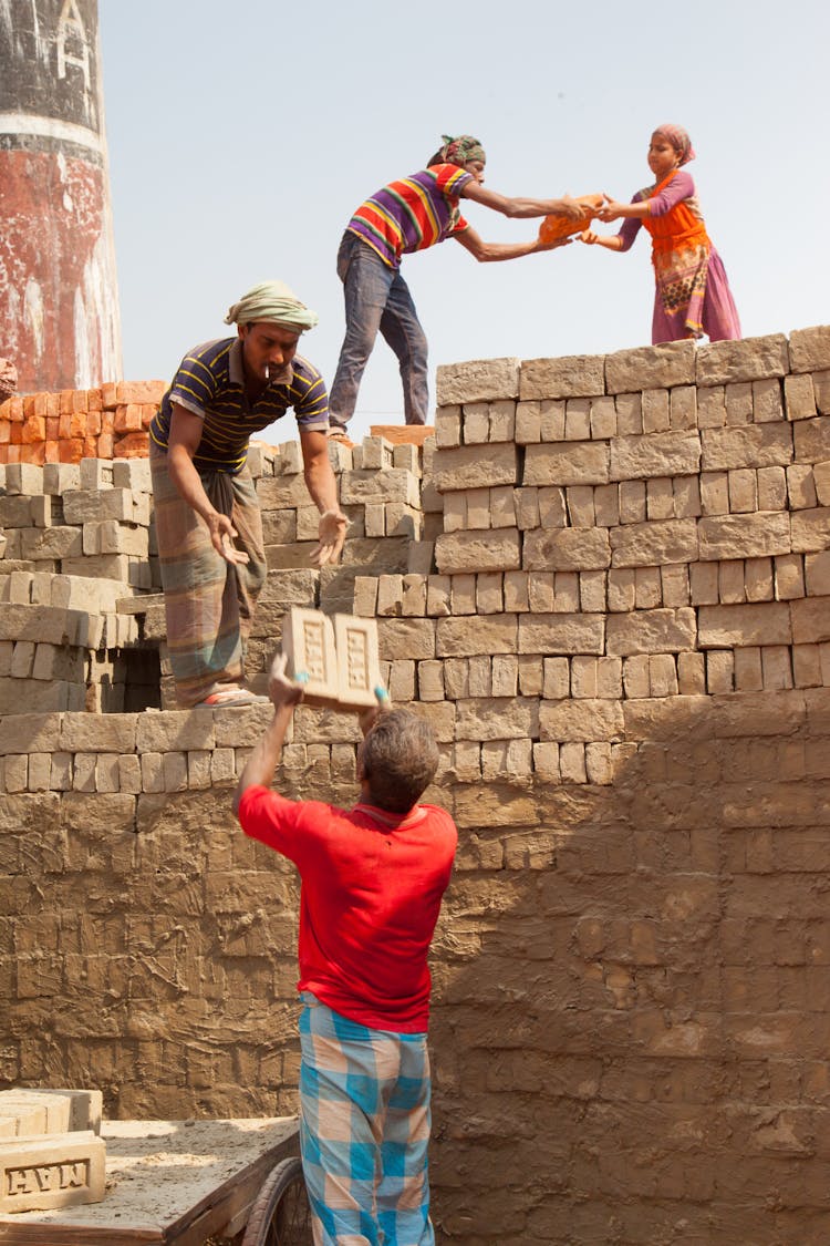 People Passing Bricks At Work