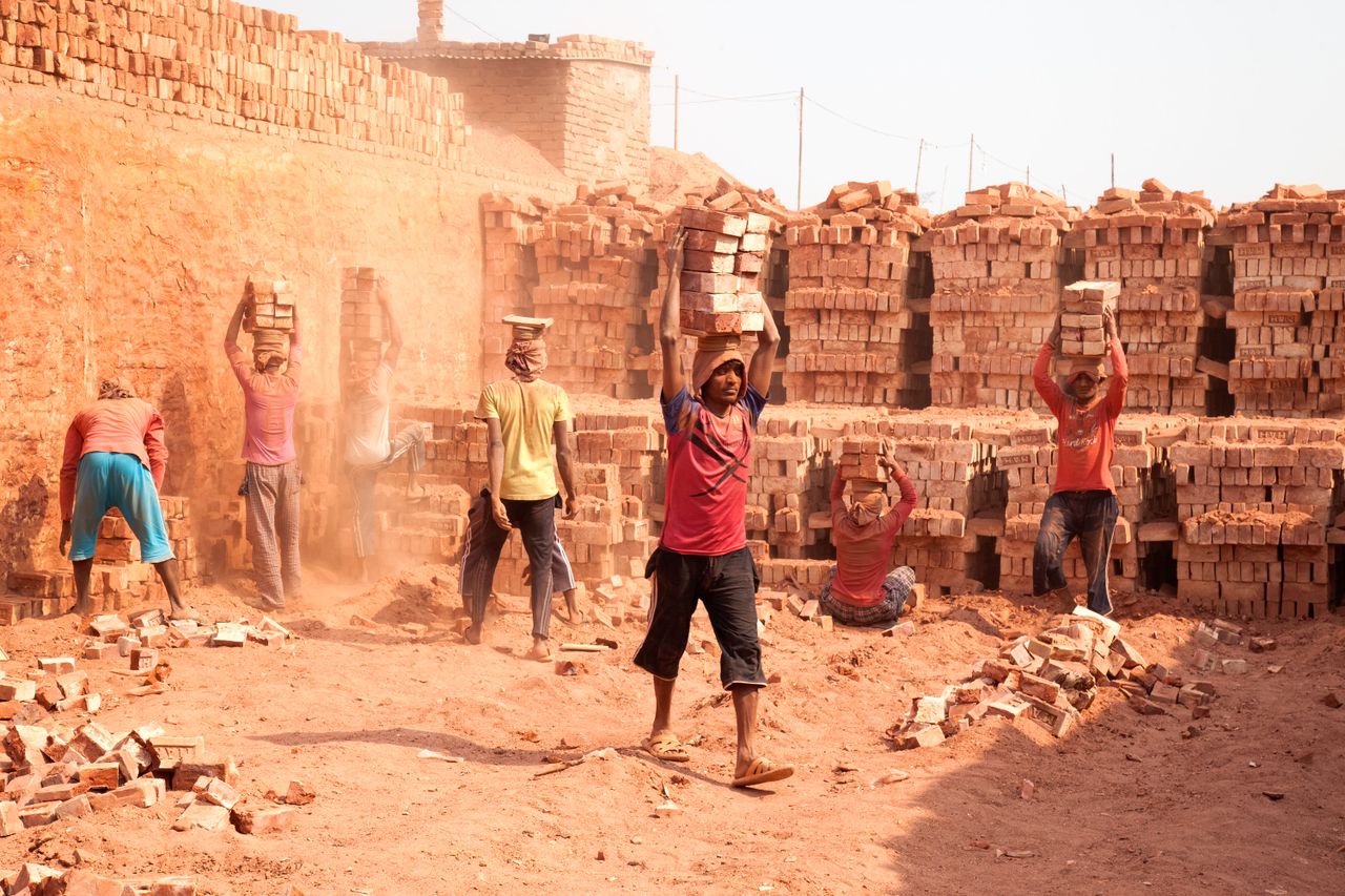 laborers carrying bricks at outdoor kiln in gabtoli dhaka bangladesh