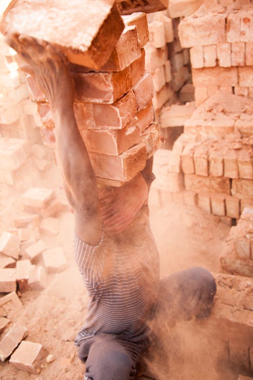 Person with pile of bricks on the head