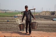 A Man Carrying Tin Pails