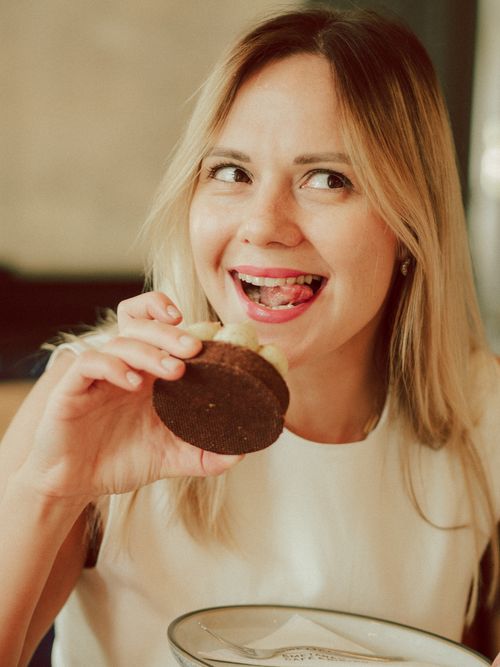 Free Happy woman savoring a delicious chocolate cupcake indoors. Stock Photo