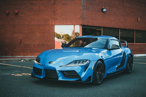 Blue Sports Car Parked Near Brick Building