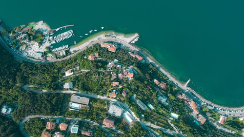 Free Stunning aerial view of Nago-Torbole's coastline, showcasing lush greenery and serene waters. Stock Photo
