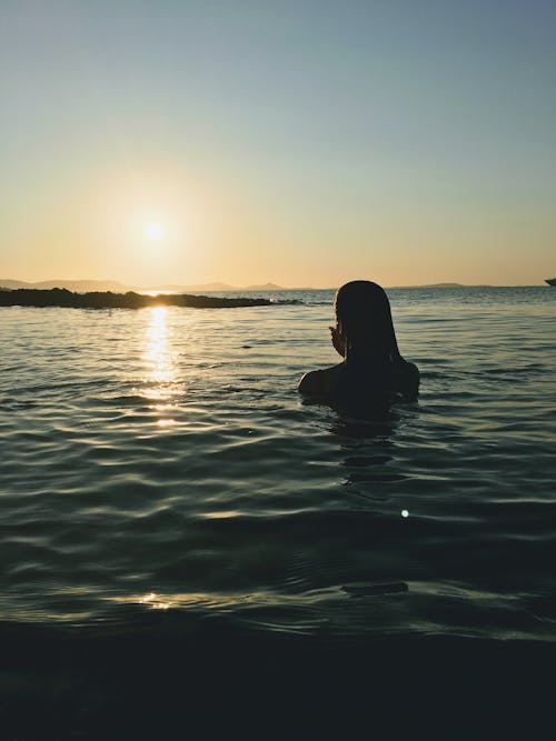 Woman in Water During Sunset