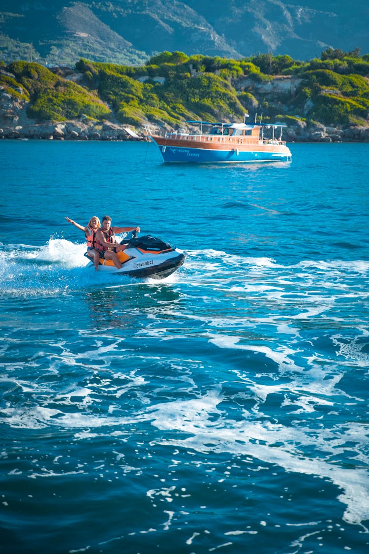 Man And Woman Riding A Jetski