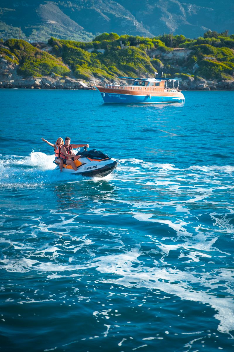 Couple riding jet ski on turquoise sea