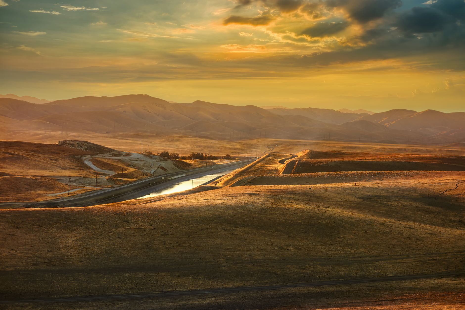 Scenic view of a vibrant sunset over the rolling hills of Merced, California, highlighting its natural beauty.