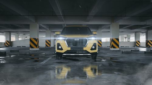 Free Yellow SUV parked indoors with headlights on in a modern garage. Stock Photo