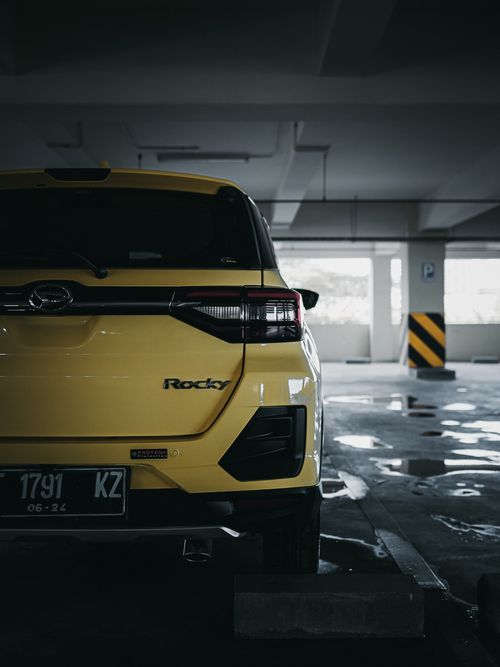 Free Rear view of a yellow car parked in an underground parking lot, highlighting urban architecture. Stock Photo