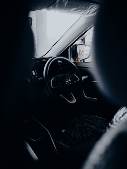 Free A sleek interior of a modern car showcasing the steering wheel and dashboard in a unique perspective. Stock Photo