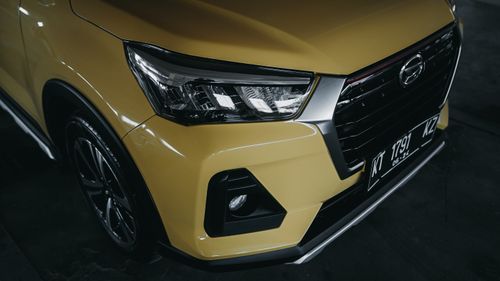Free Detailed close-up of a yellow car's front with headlights and grill, showcasing modern design. Stock Photo
