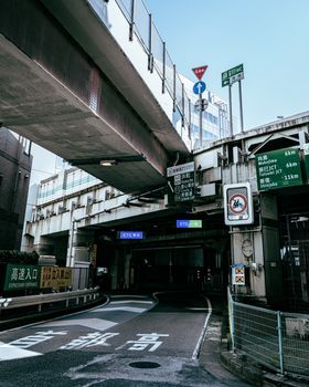 Dynamic city scene featuring a concrete overpass and multilingual traffic signs.