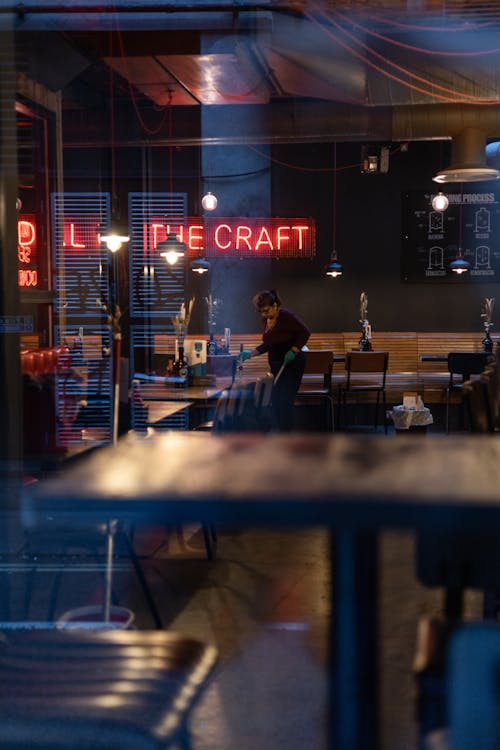 Woman Sweeping the Floor of the Restaurant