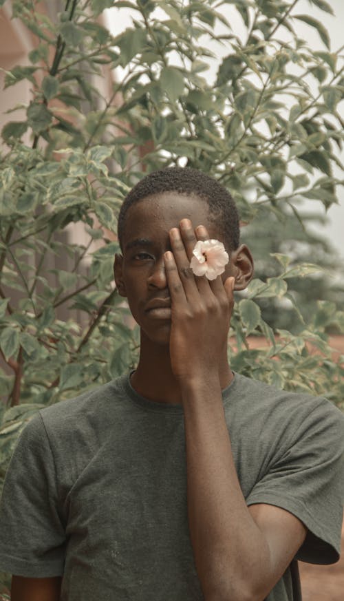 A Man Covering His Eye with a Flower