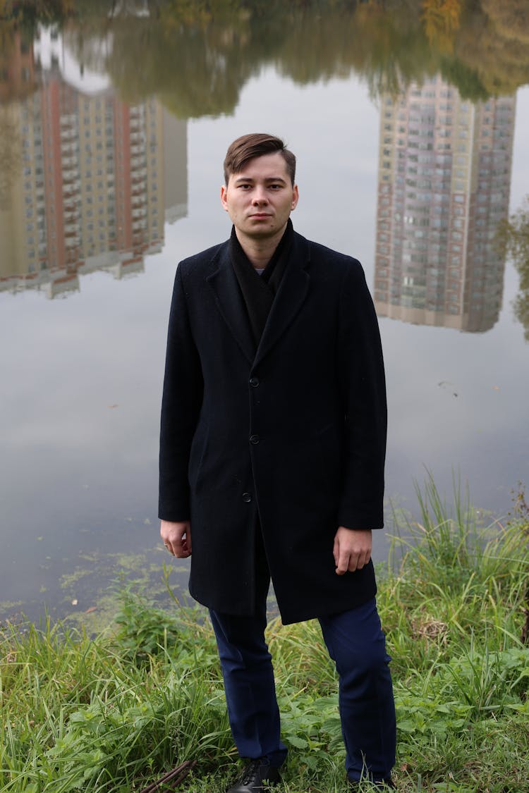 Man Standing On River Bank In City