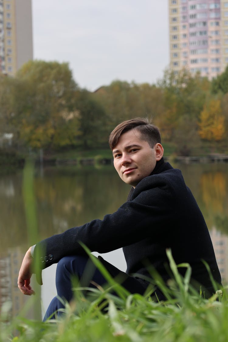 Man Sitting On Bank Near River