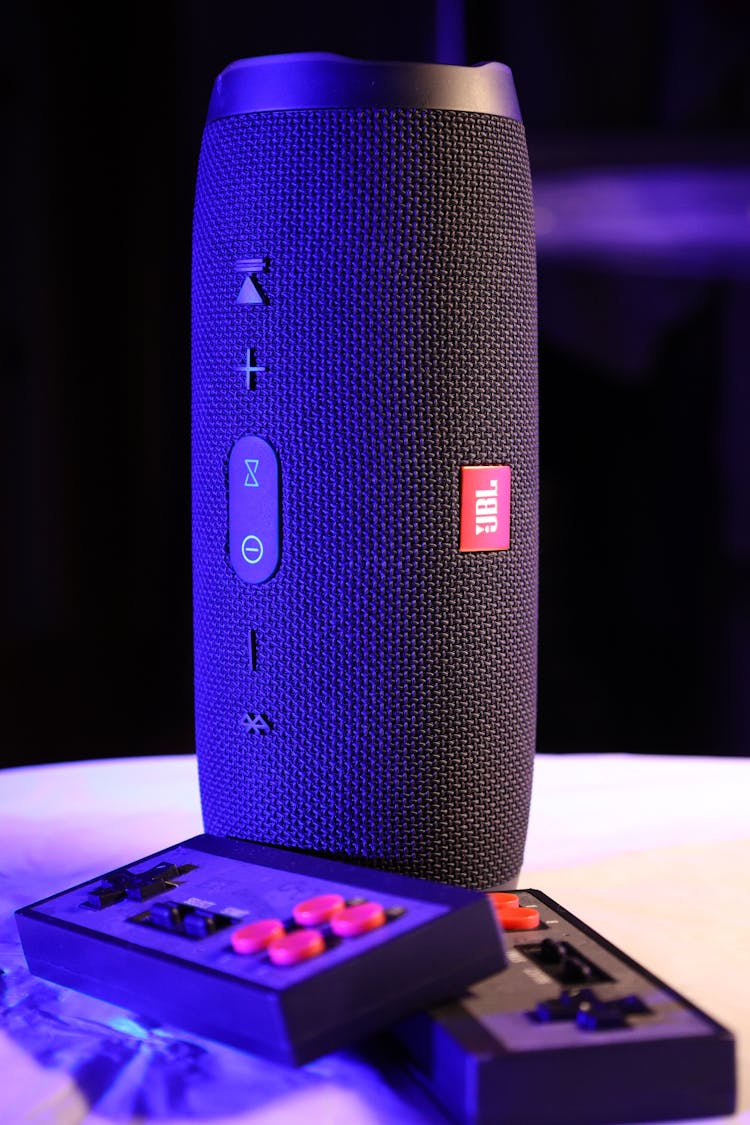 Black Jbl Portable Speaker Beside  Controllers