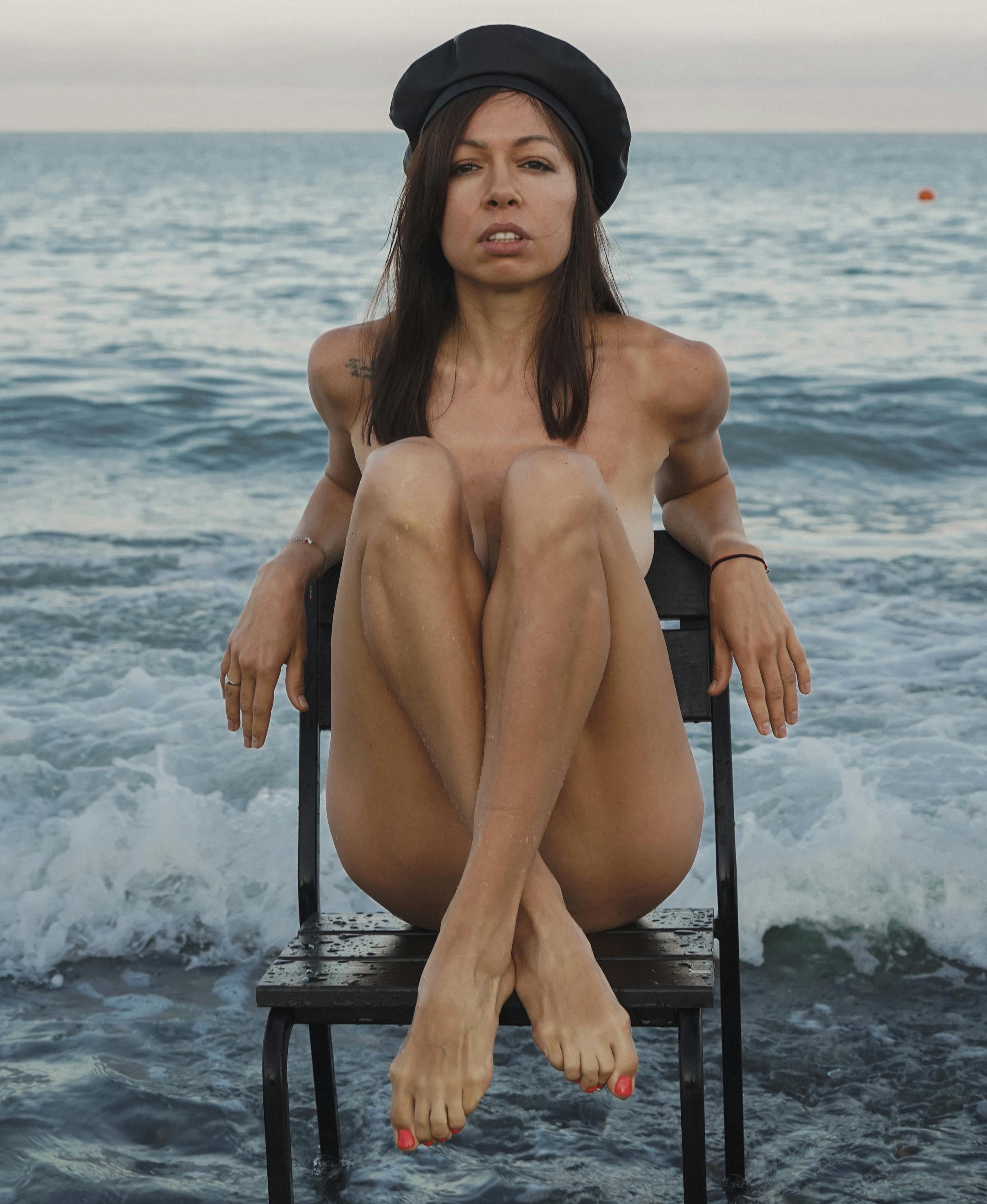 portrait of a woman sitting naked by a sea