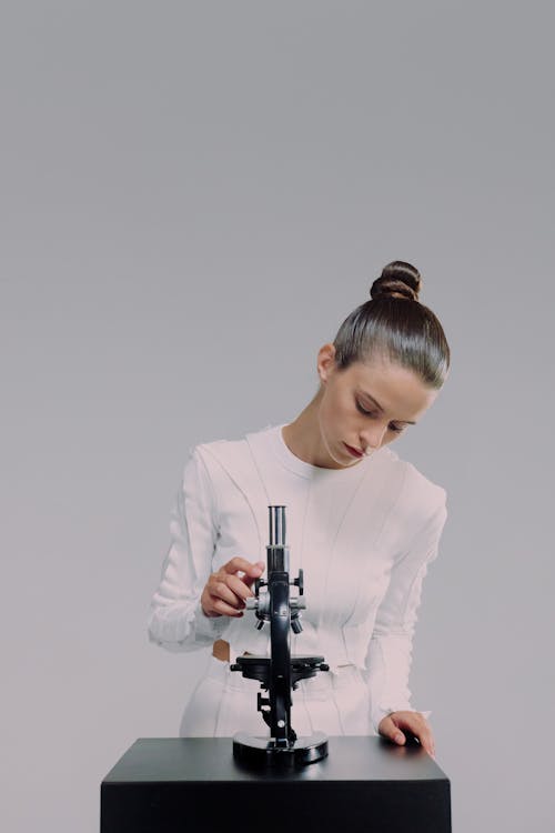Woman and microscope against white background