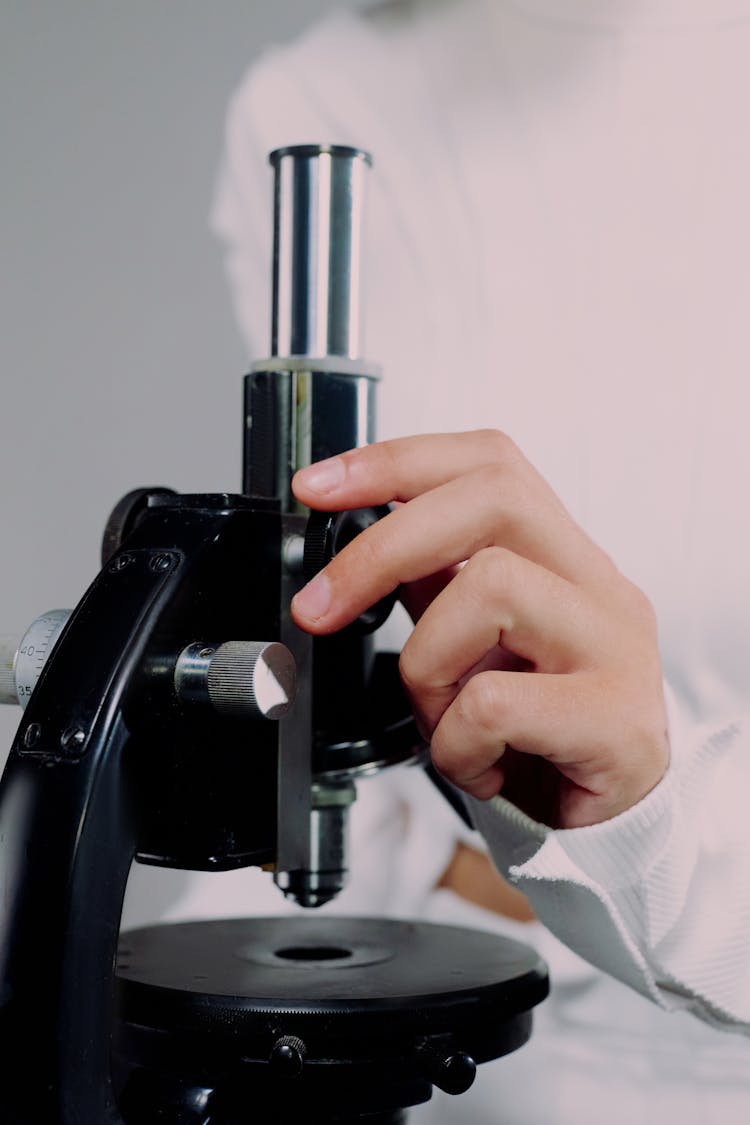 Close Up View Of Hand Holding Microscope