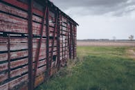 广阔的乡村景观中，一座废弃的红色木谷仓映衬其间，展现着乡村魅力