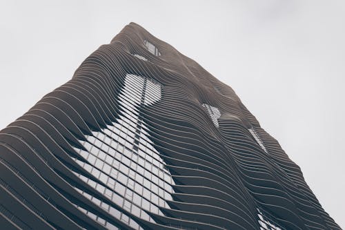 Black and white low angle of contemporary multistory house facade with ribbed walls under sky in town