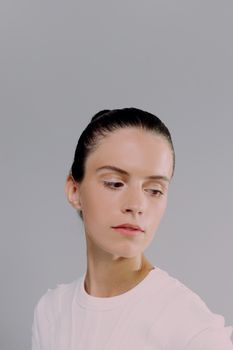 Elegant female portrait against a white background, looking away with a serene expression.
