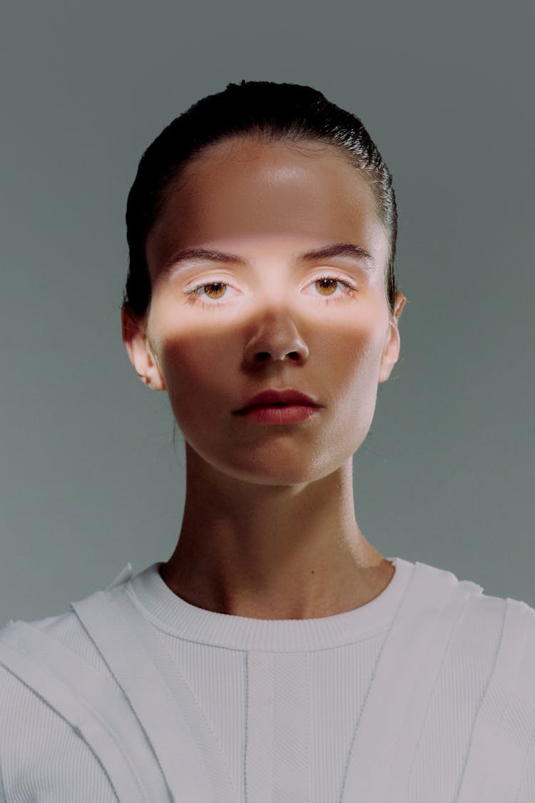 A Headshot of Female Scientist Looking At Camera With A Light Falling On Her Eyes 