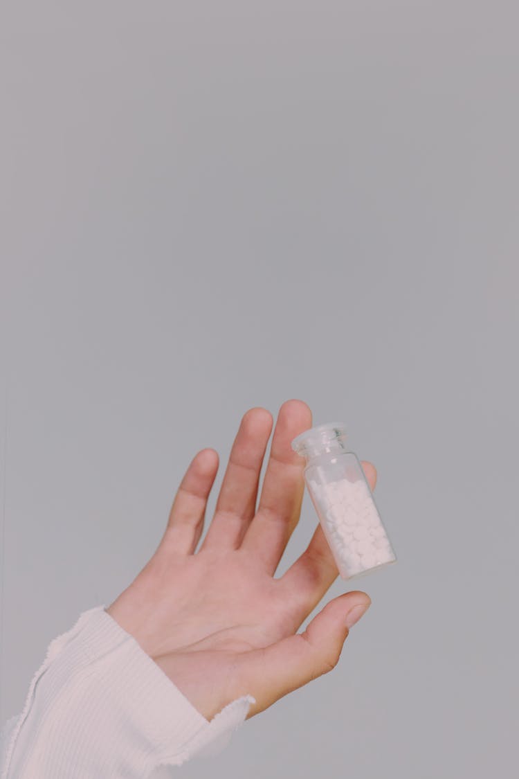 A Female Hand Holding A pill Vial