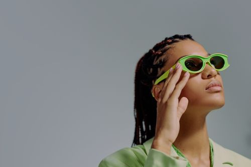 Free Elegant studio portrait of a woman wearing bold green sunglasses, exuding chic fashion vibes. Stock Photo