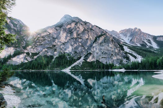 在晴朗的天空下，宁静的高山湖泊倒映着令人惊叹的山脉景观