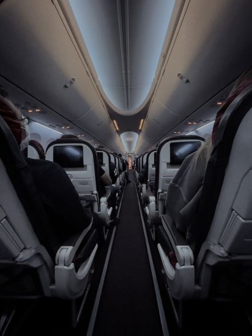 Free View of airplane cabin showing passengers seated during flight. Stock Photo