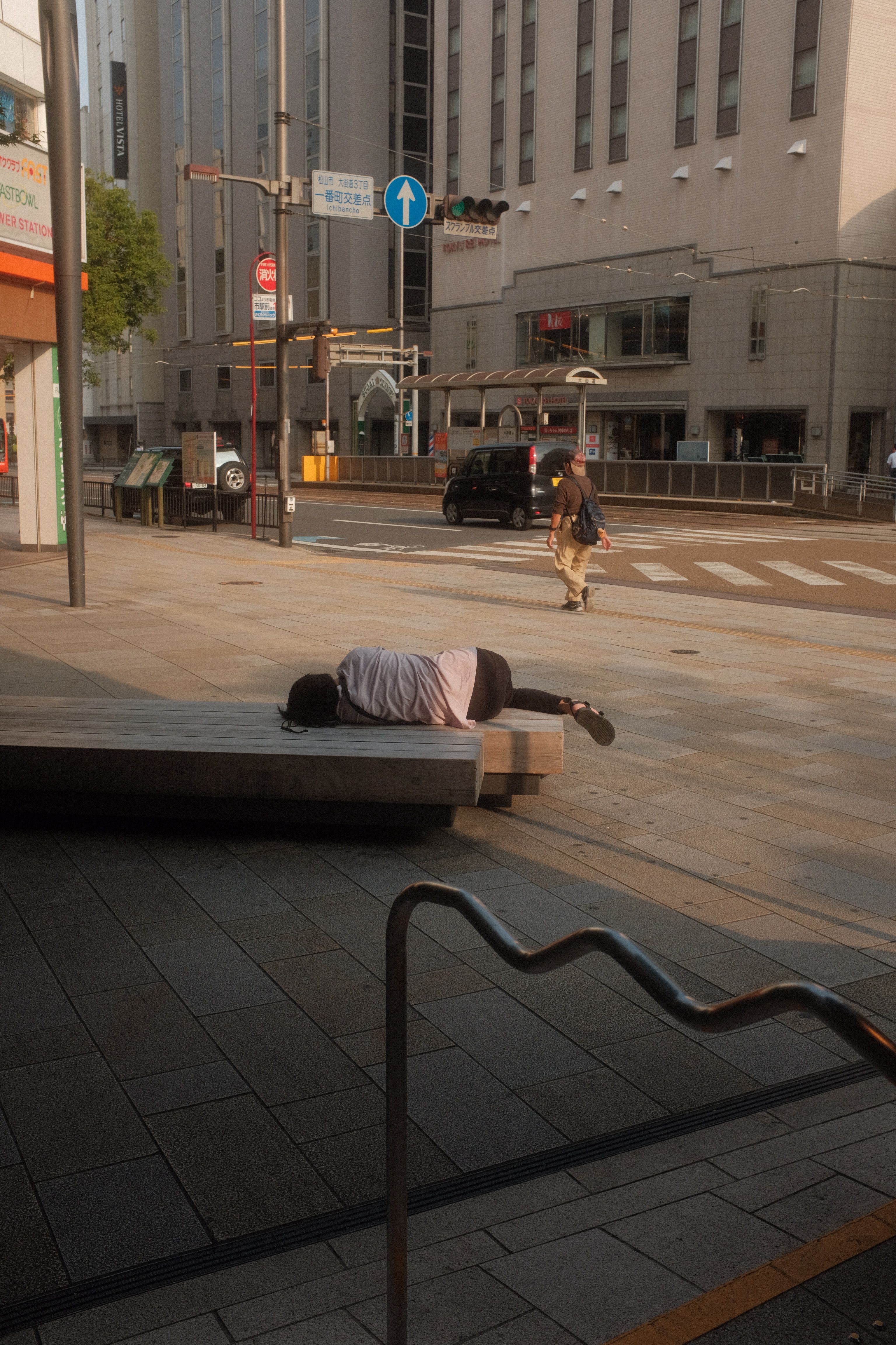Person Lying on a Concrete Bench at the Street · Free Stock Photo